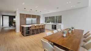 Una cocina moderna con una isla central, armarios de madera y un ventanal grande.