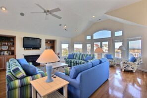 Télévision, cheminée, lecteur de DVD, livres