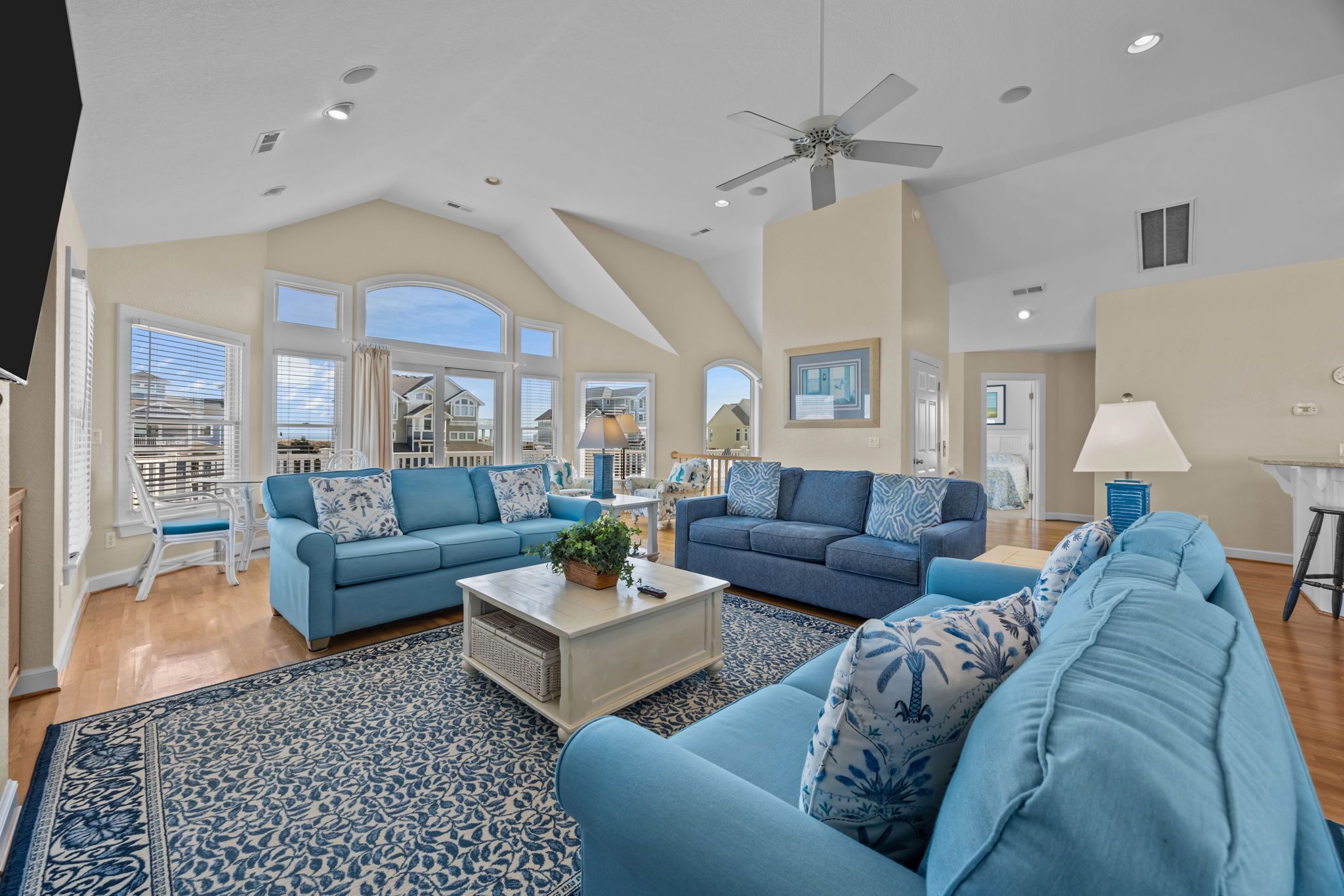A spacious living room with two sofas, a coffee table, and a ceiling fan.