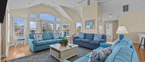 A spacious living room with two sofas, a coffee table, and a ceiling fan.