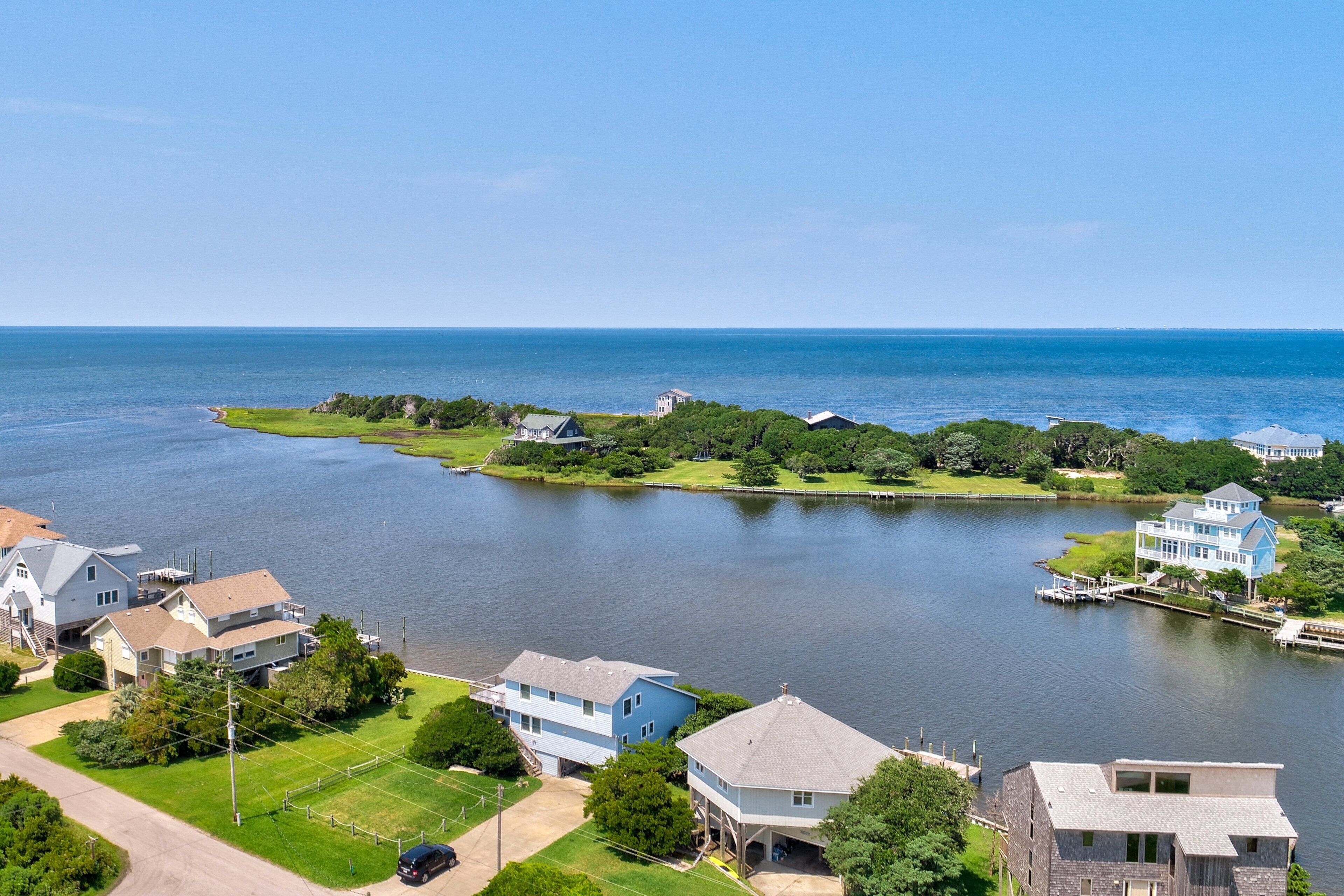 A lakeside residential area with houses, a dock, and a clear view of the lake.