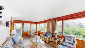 A spacious living area with a sofa, chairs, and a coffee table, large windows with curtains, and a view of greenery outside. - Waterfront, Dog-Friendly House w/Shared Pool, Free WiFi, Private W/D, Central AC (Frisco)