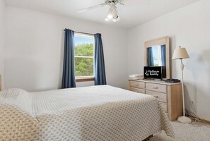A bedroom with a bed, a dresser, a mirror, a ceiling fan, and a window with curtains. - Waterfront House w/ Private Hot Tub, Washer/Dryer, Shared Pool, Central AC, WiFi (Frisco)