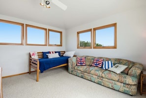 A room with a bed, a sofa, and two windows. - Waterfront House w/ Private Hot Tub, Washer/Dryer, Shared Pool, Central AC, WiFi (Frisco)