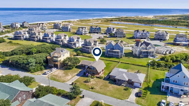 An aerial view of a coastal residential area with houses, a clear blue sky, and the ocean in the background. - Beautiful house w/Shared Pool, Private Washer/Dryer, Central AC, Free WiFi (Buxton)