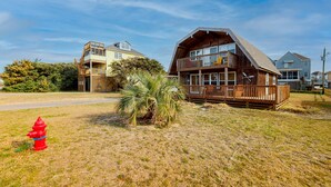 A coastal house with a wooden deck, a fire hydrant, and a palm tree. - Beautiful house w/Shared Pool, Private Washer/Dryer, Central AC, Free WiFi (Buxton)