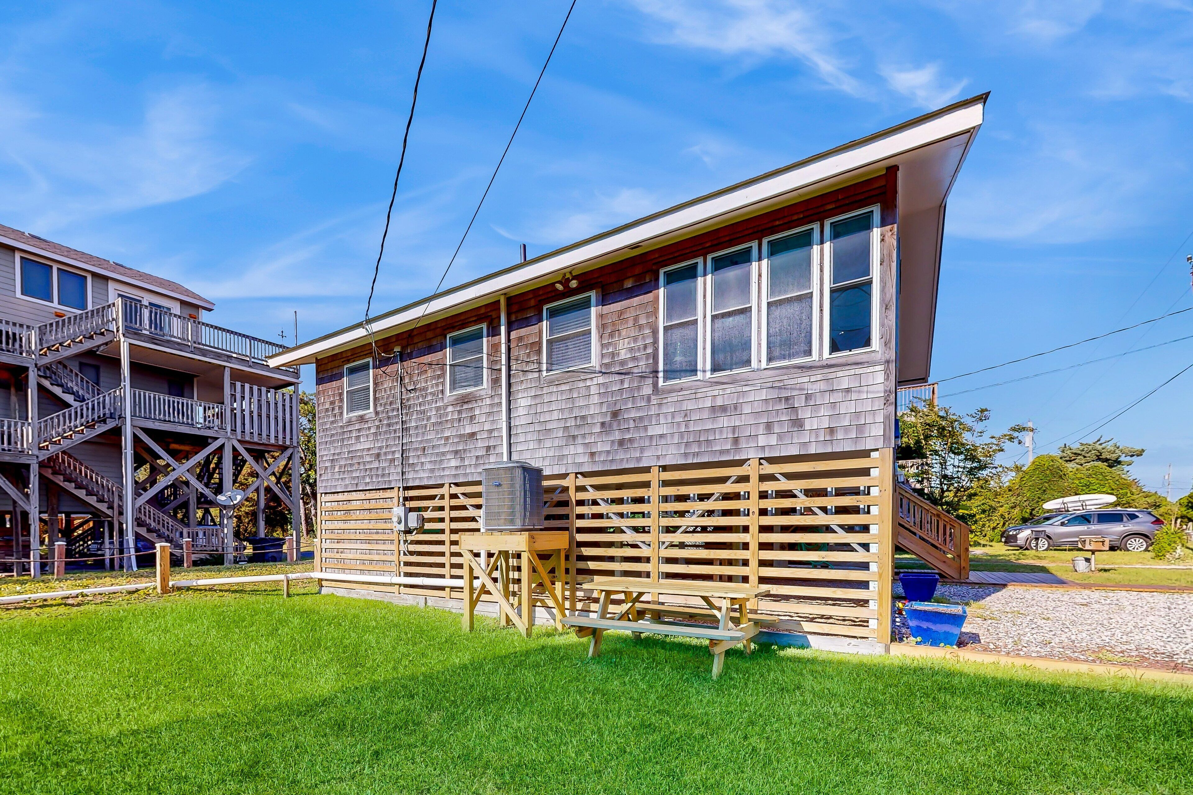 A two-story building with a wooden deck and a staircase leading to an upper level.