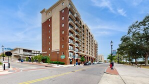 A multi-story hotel with a brick facade, multiple balconies, and a clear blue sky. - Historical Riverfront Condo in Historic District, Highly Walkable Locale (Wilmington)