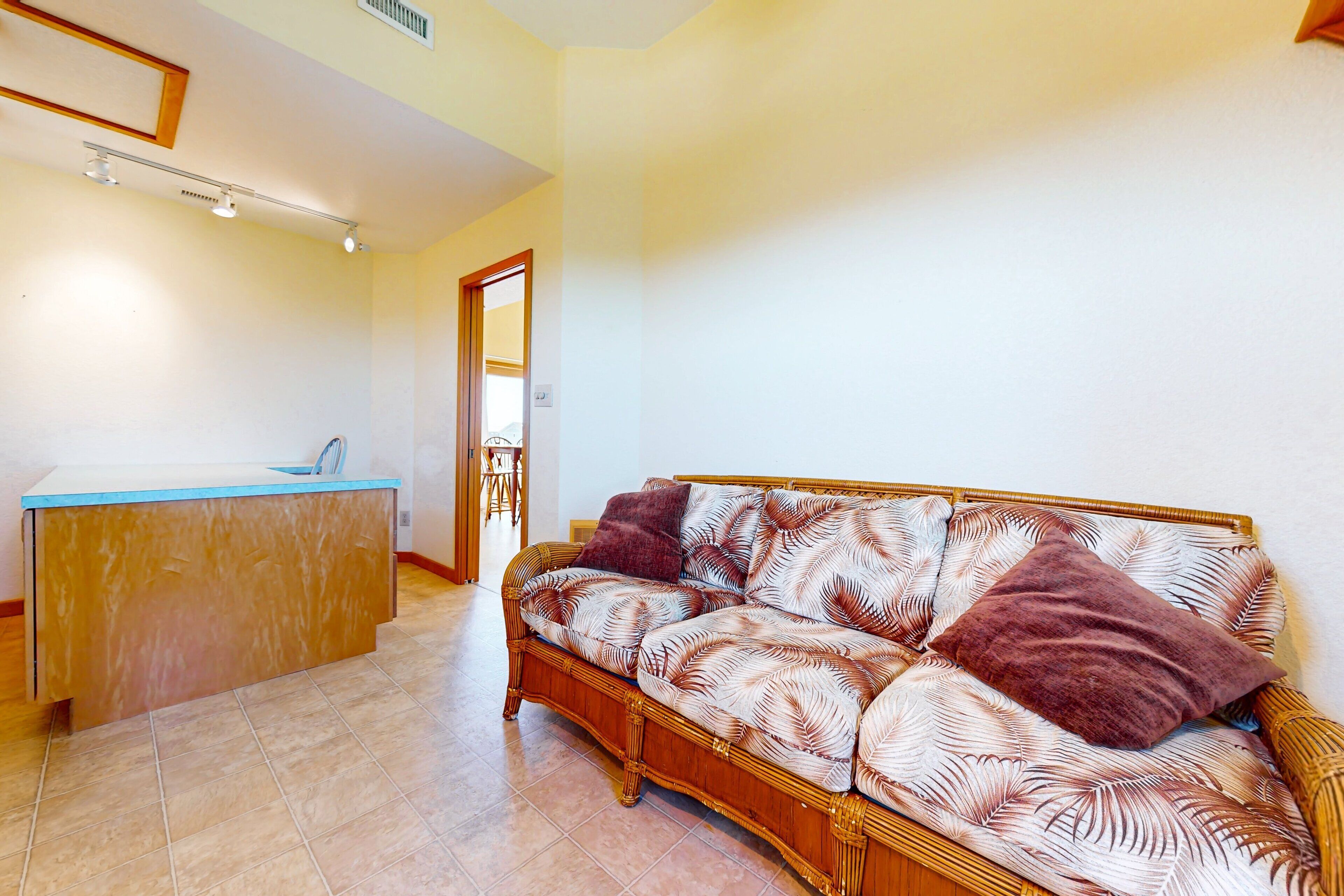 A living room with a sofa and a small kitchenette area.
