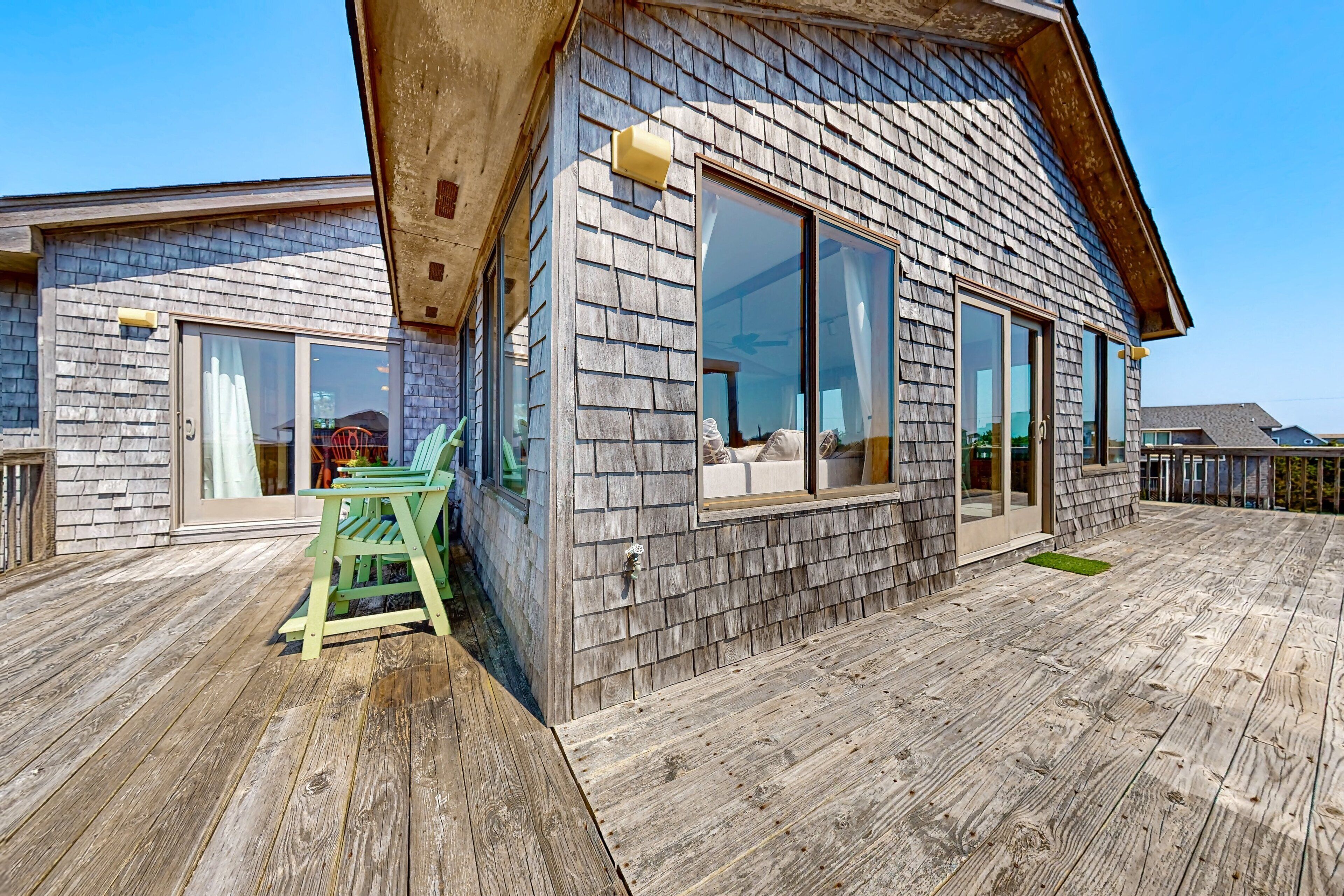 A wooden deck with a green chair and a small table.