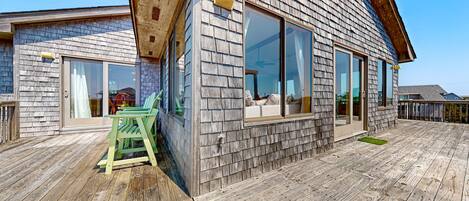 A wooden deck with a green chair and a small table.