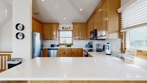 Una cucina moderna con mobili in legno, un frigorifero in acciaio inossidabile e una grande isola.