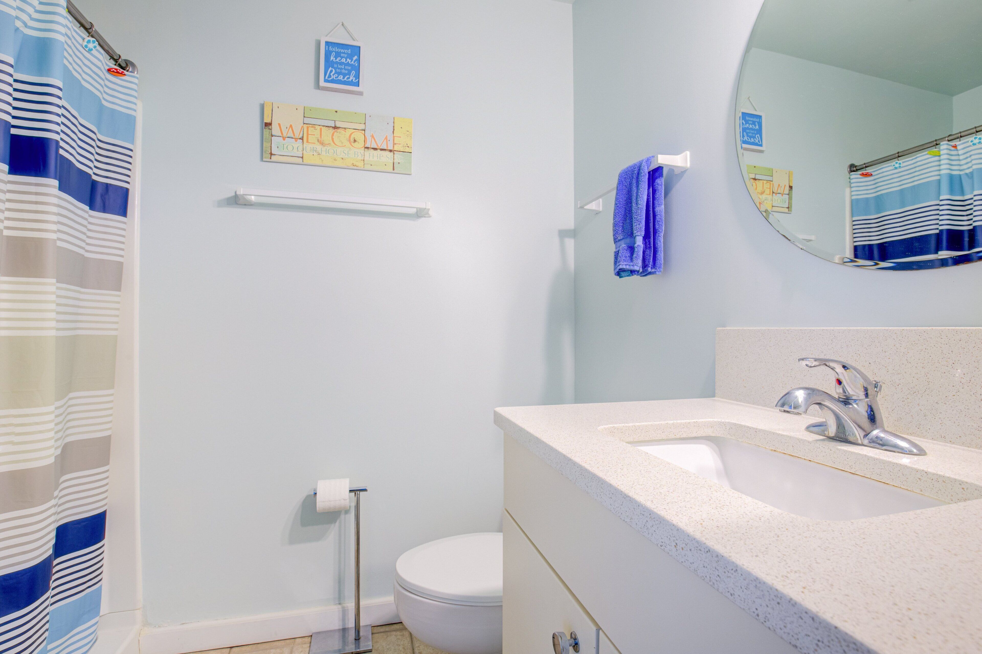 A bathroom with a white sink, a mirror, a towel rack, and a toilet.
