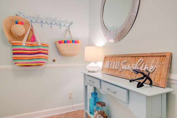 A light blue vanity with a mirror, a "Hello Sunshine" sign, a striped bag, and a straw hat. - Beachfront condo with a pool, hot tub, tennis, washer/dryer & central AC (North Topsail Beach)