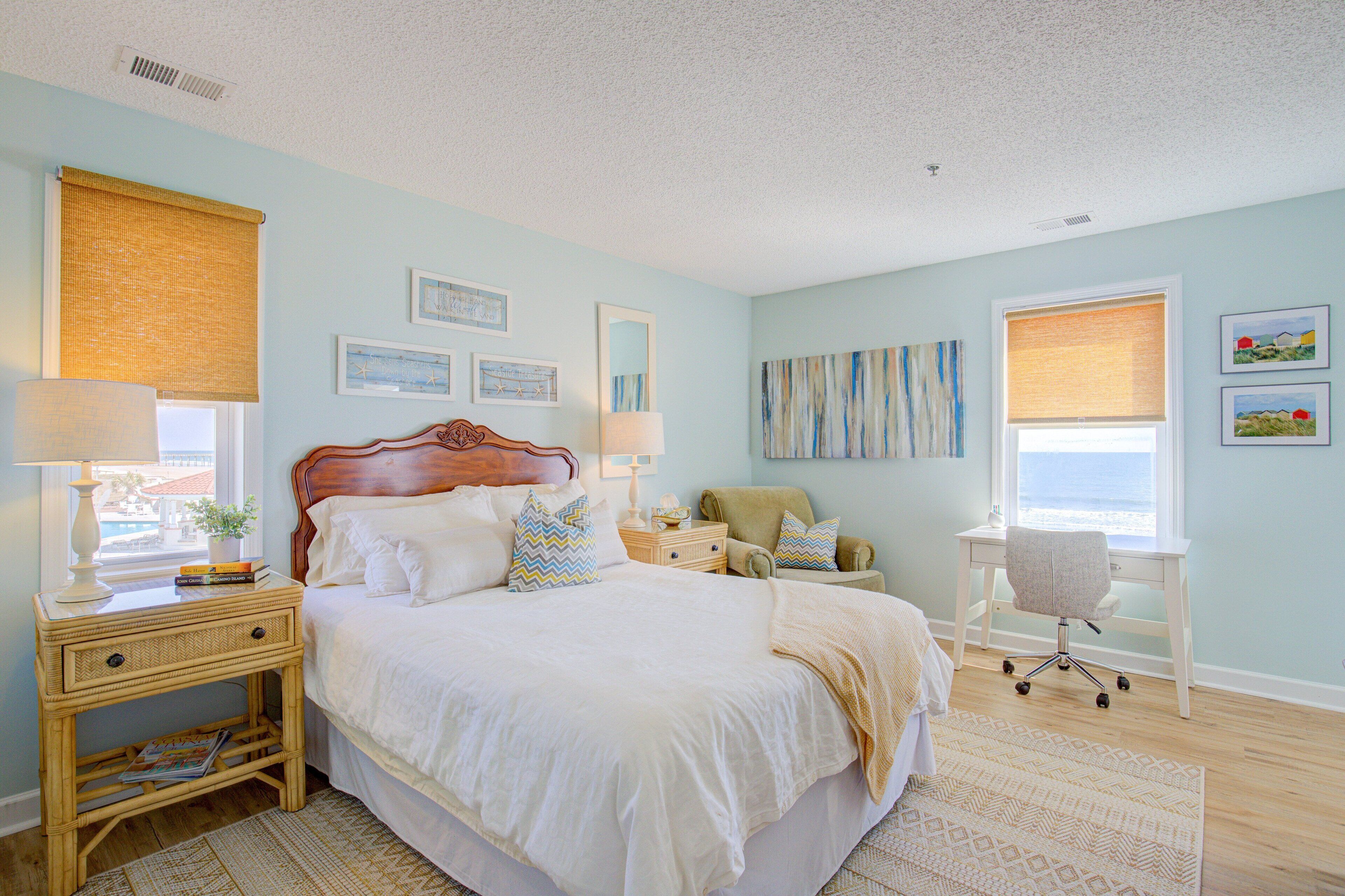 A bedroom with a bed, bedside tables, a chair, and artwork on the walls.