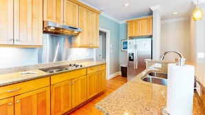 A modern kitchen with wooden cabinets, stainless steel appliances, granite countertops, and a built-in oven. - Beautiful beach house with an elevator, washer/dryer, & AC - walk to the beach (Wrightsville Beach)