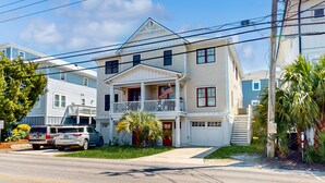 A two-story house with a balcony, a garage, and a driveway. - Beautiful beach house with an elevator, washer/dryer, & AC - walk to the beach (Wrightsville Beach)