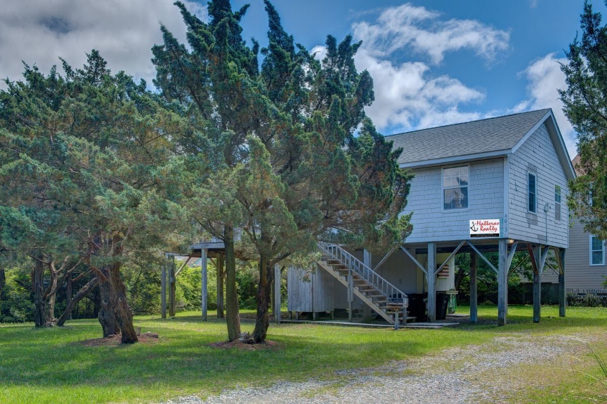 A two-story house with a covered porch and a staircase leading to the second floor.