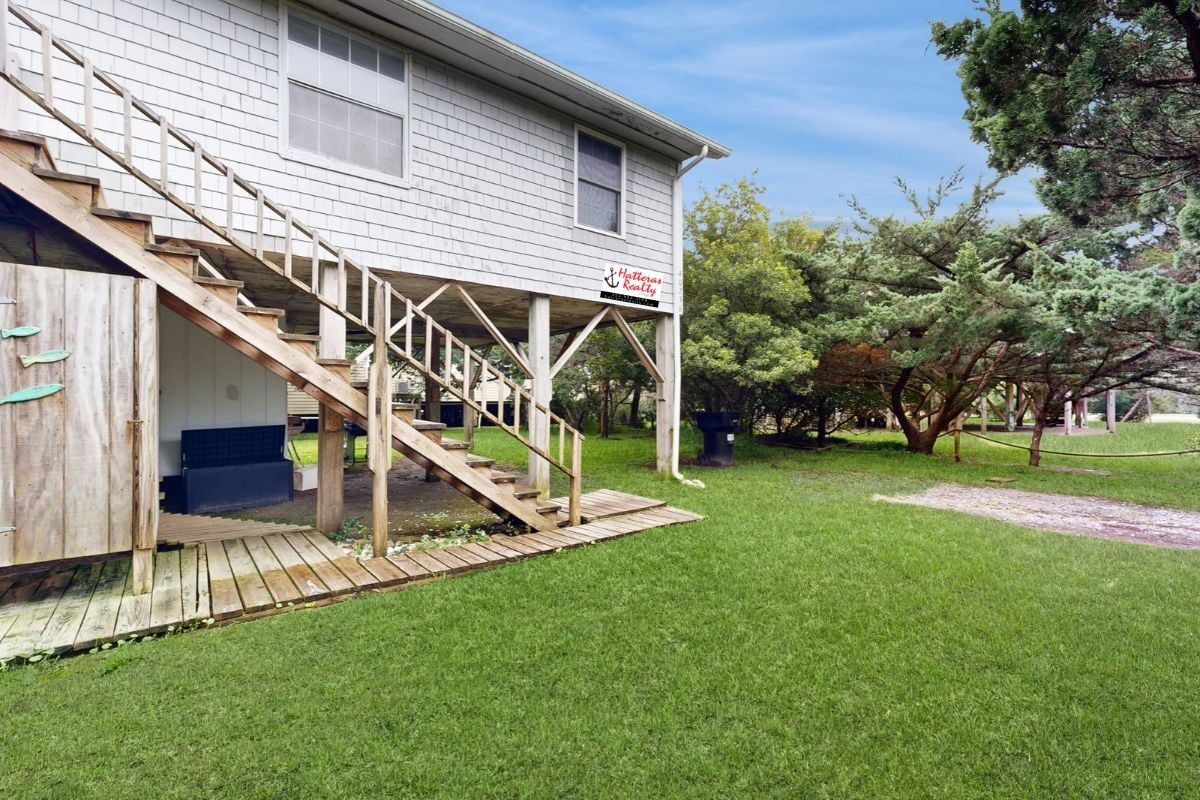 A two-story house with a wooden staircase leading to a porch.