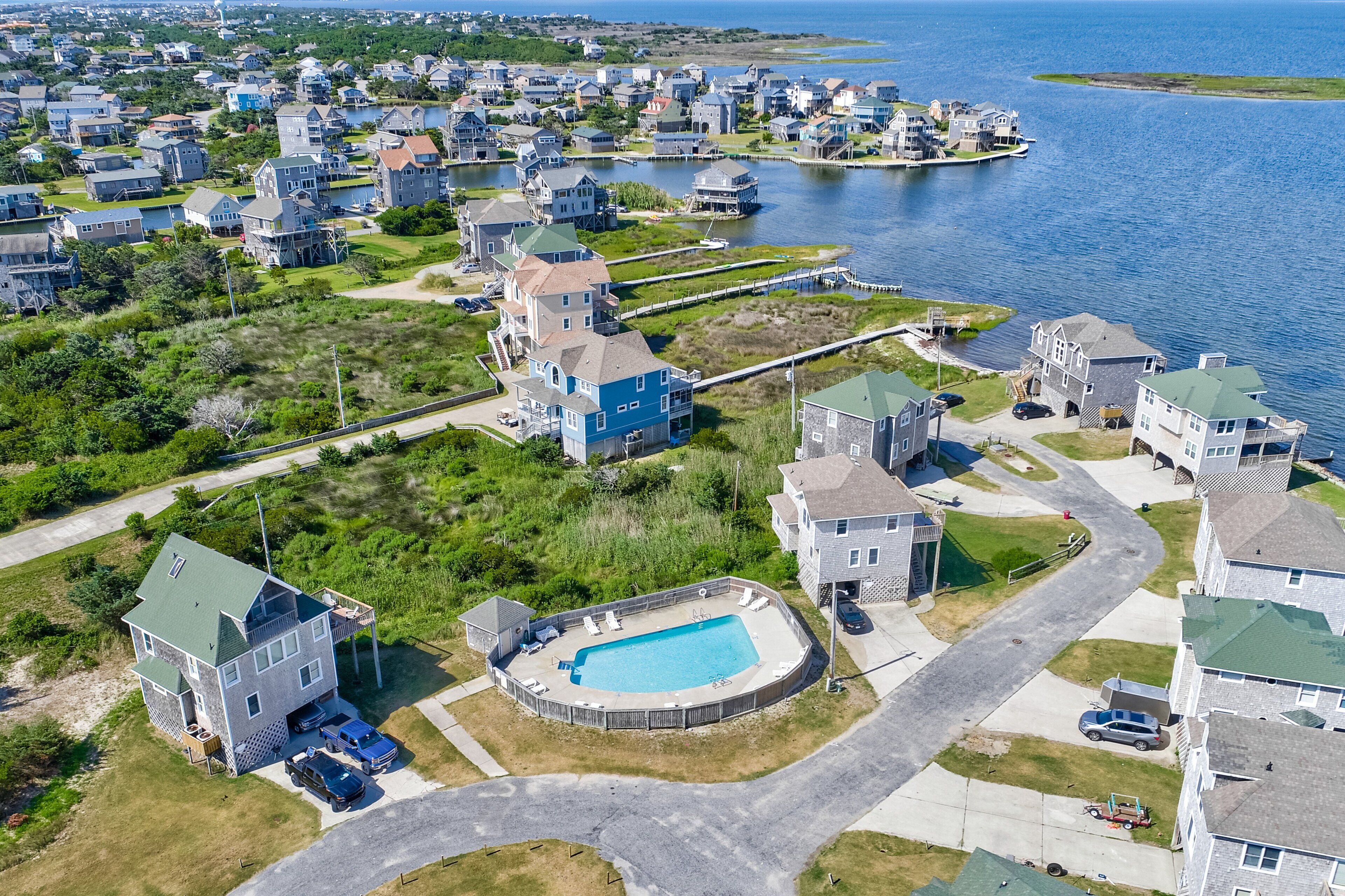 Vue aérienne d’un quartier résidentiel avec des maisons, un quai et une piscine.