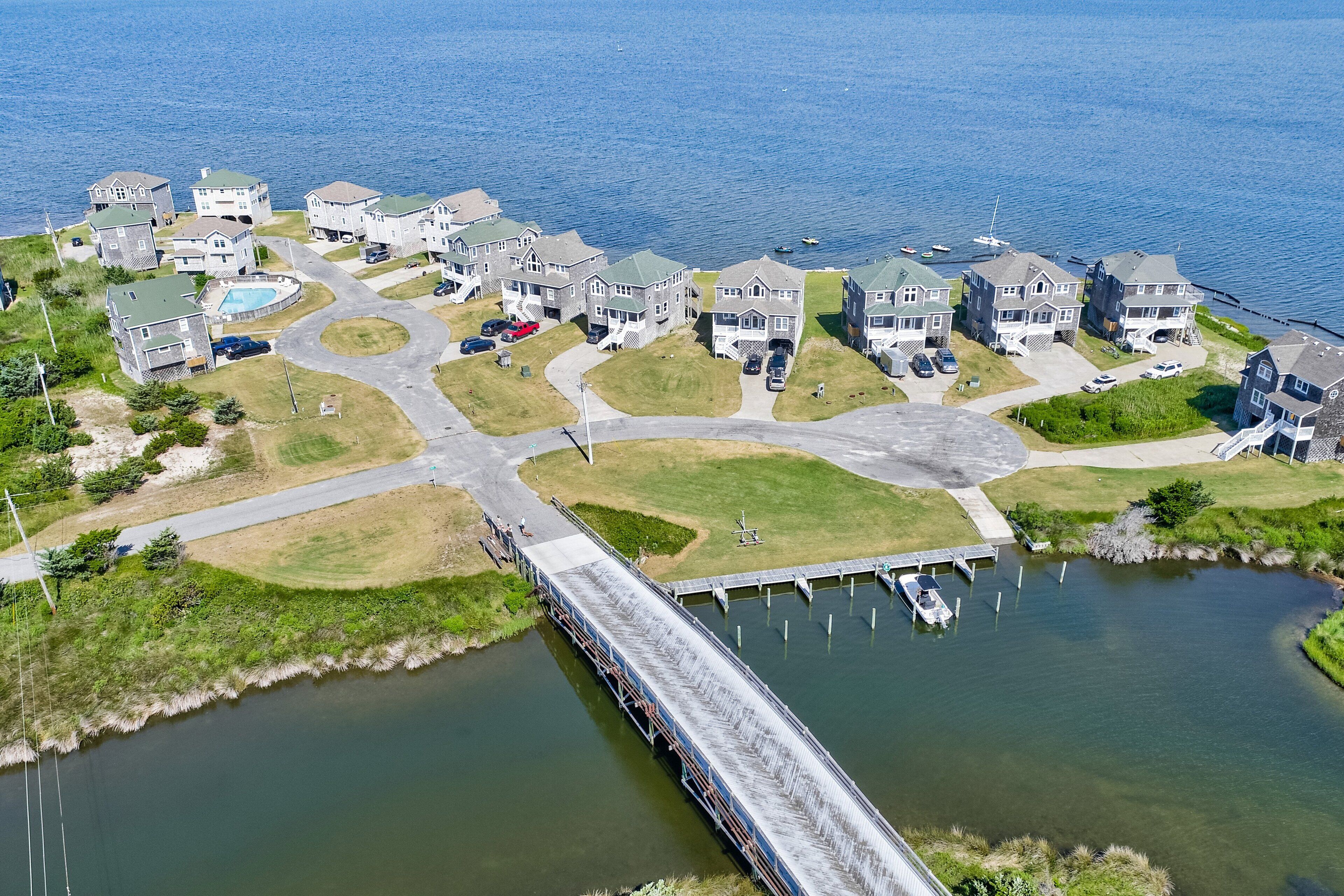 Un quartiere residenziale con case, un molo e una piccola distesa d'acqua.