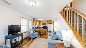 A modern living room with a TV, seating, and a staircase. - Great sound view waterfront home with private hot tub, AC, W/D & pool access (Avon)