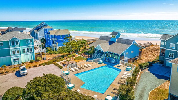 Ein Resort mit Schwimmbad, Blick auf den Strand und mehreren Gebäuden.