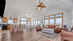 A spacious living area with a kitchen, dining set, and seating. - Sound front home with amazing views, private pool, hot tub, theater & rec room (Avon)