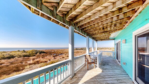 A wooden deck with a view of the beach and ocean. - Sound front home with amazing views, private pool, hot tub, theater & rec room (Avon)