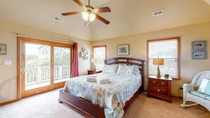 A bedroom with a large bed, a ceiling fan, a rocking chair, and a view through a sliding glass door. - 3-story luxury home with pool, hot tub, AC, tennis, & deck - dog-friendly (Avon)