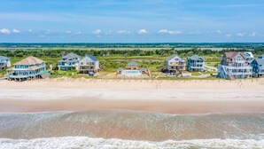 A beachfront property with multiple houses, a sandy beach, and a view of the ocean. - Spacious, dog-friendly home with ocean views, beach access, & pool (North Topsail Beach)