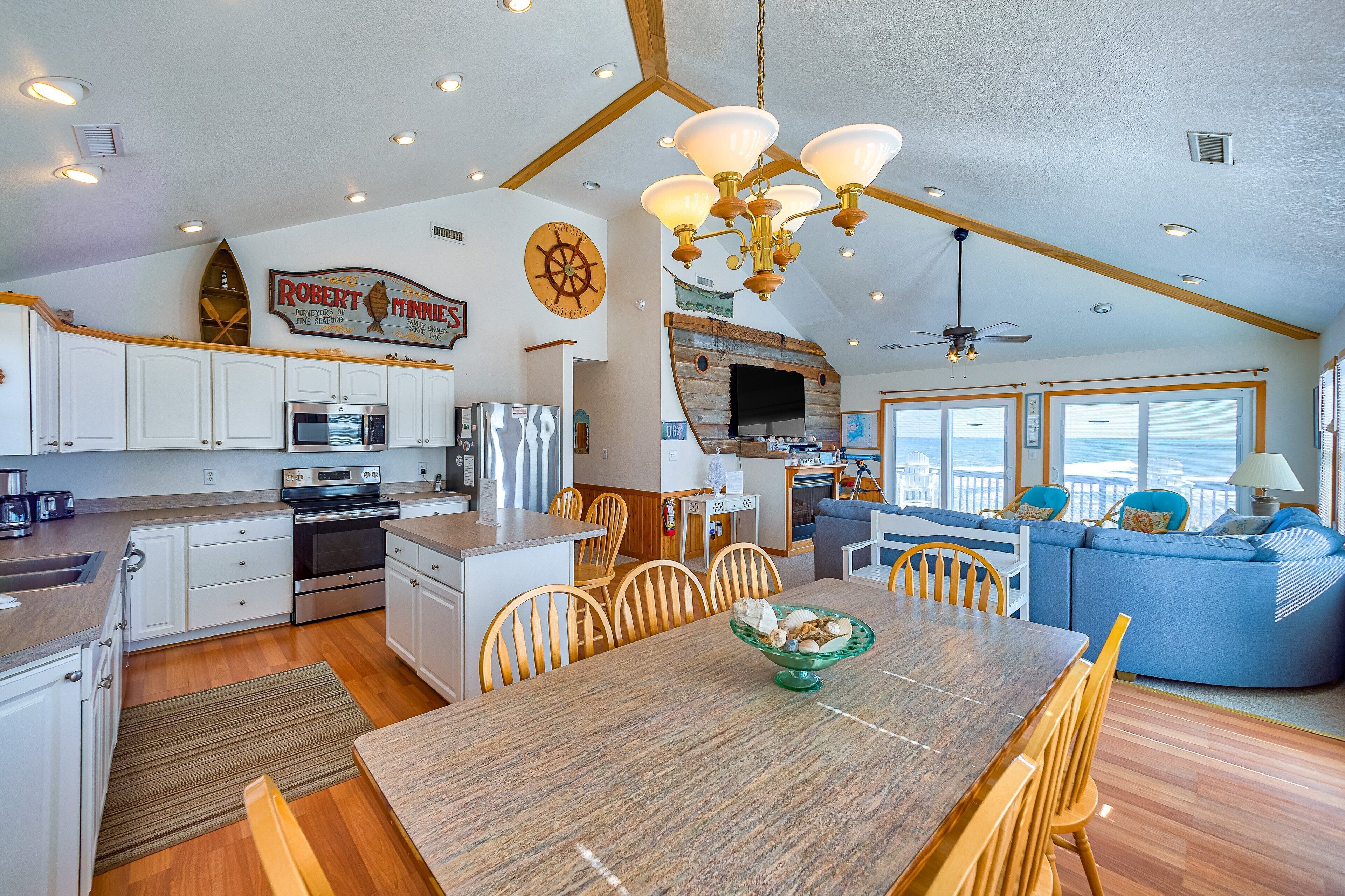 A spacious kitchen with modern appliances, a dining area with a wooden table, and a cozy seating area with a view.