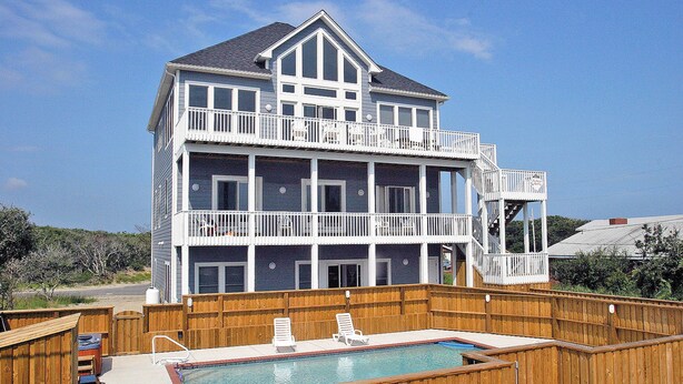 A two-story house with a balcony and a swimming pool. - Ocean-view home with central AC, pool, & hot tub (Buxton)