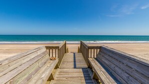 A wooden boardwalk leading to a beach with a clear blue sky. - Beachfront, multi-level home with pool, beach access & private hot tub (North Topsail Beach)