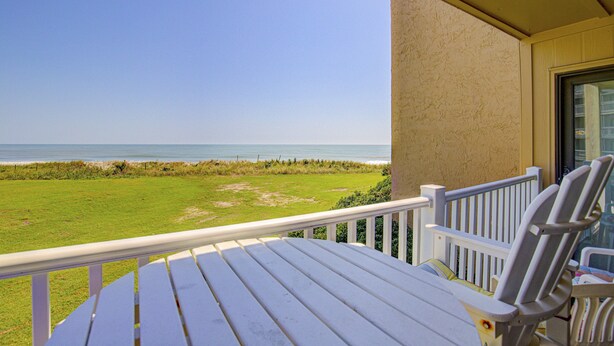 Ein Balkon mit Blick auf Strand und Meer.