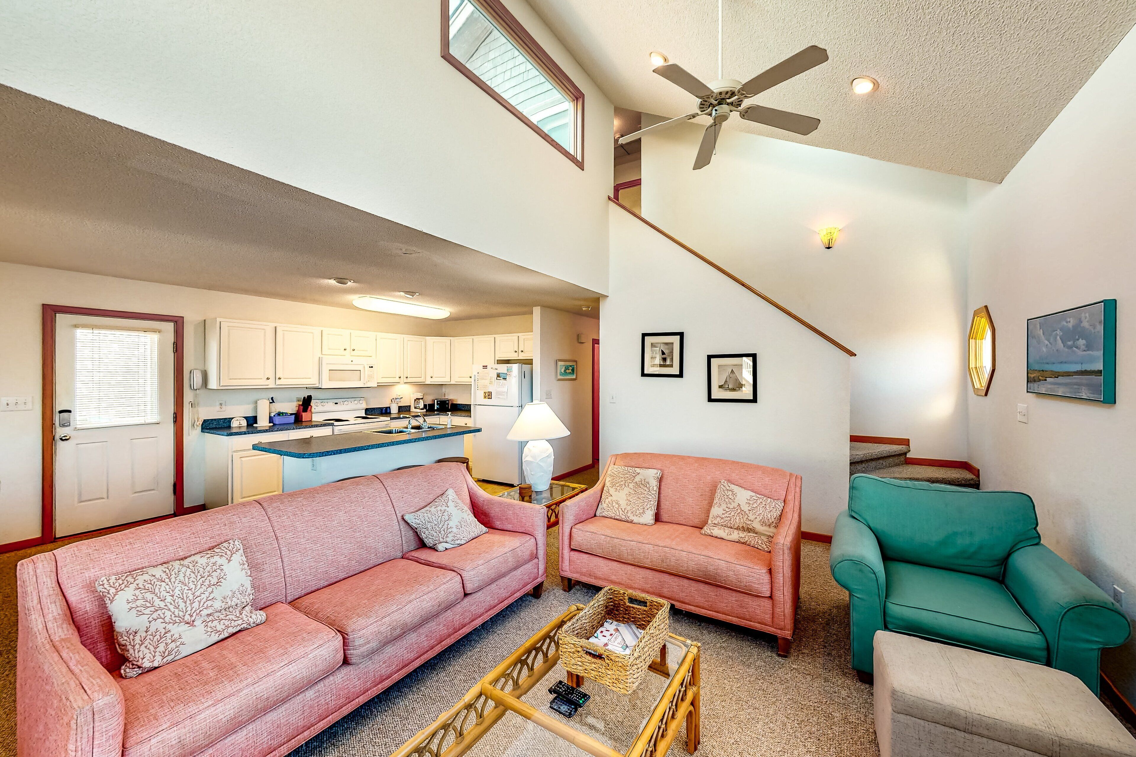A spacious living area with two sofas, a coffee table, and a staircase leading to an upper level.