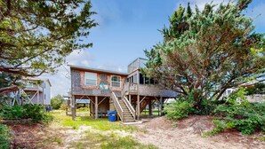 A two-story house with a deck and a staircase leading to a second floor. - Pelican's Roost 467: Semi-oceanfront, dog-friendly, outdoor pool/tennis (Avon)