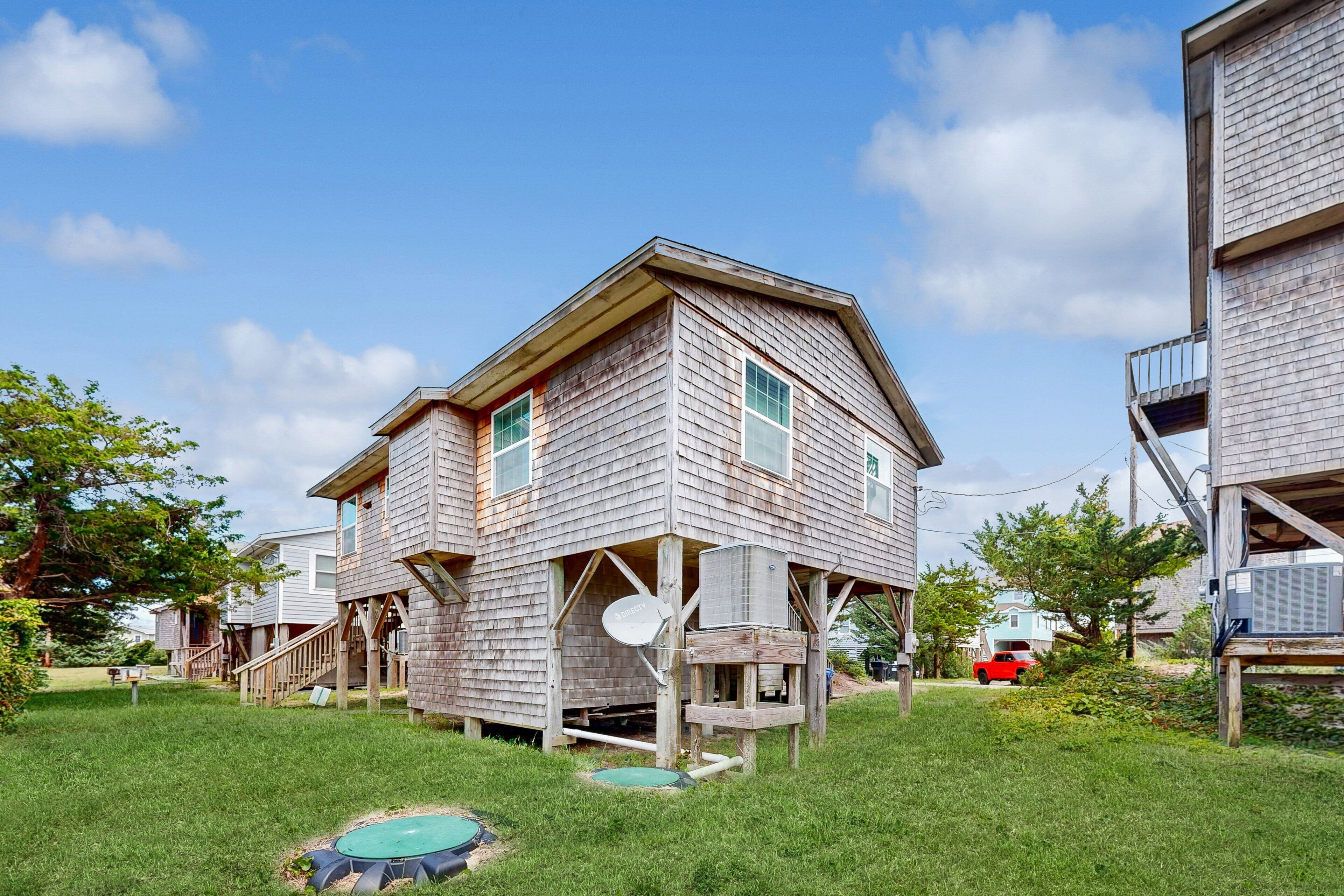 A two-story wooden house with a balcony and a satellite dish.