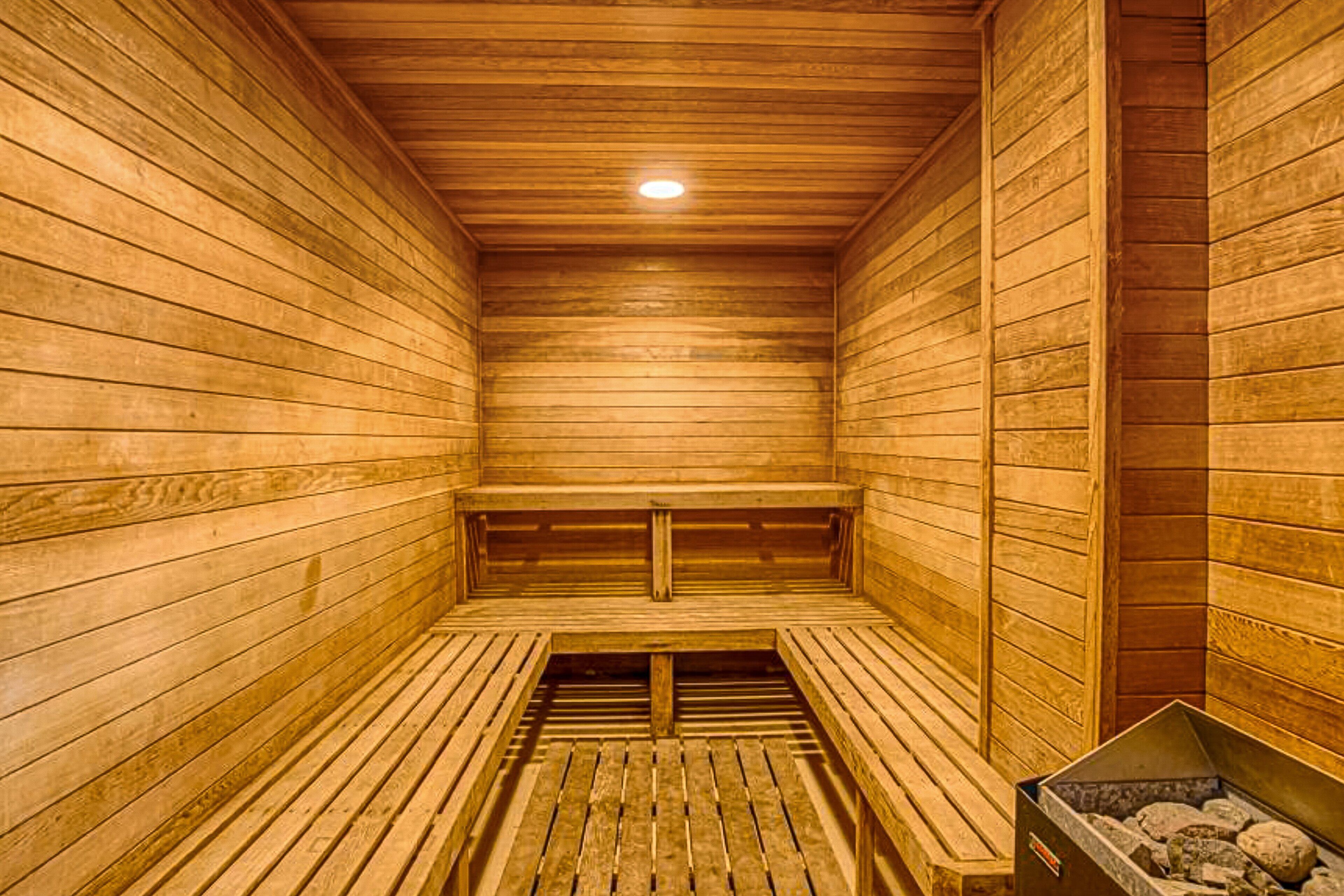 Un sauna avec des murs et des bancs en bois.