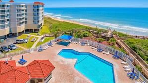 A hotel with a swimming pool, beach access, and a view of the ocean. - St. Regis beachfront condo with ocean & pool-view balcony, gym & sauna (North Topsail Beach)