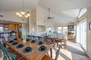 A spacious living area with a dining table set for four, a sofa, and a coffee table. - Sunshine: Semi-oceanfront, private pool, hot tub, ocean view (Avon)