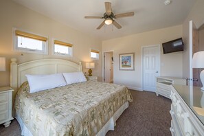 A bedroom with a bed, nightstands, a dresser, a ceiling fan, and a television. - Sunshine: Semi-oceanfront, private pool, hot tub, ocean view (Avon)