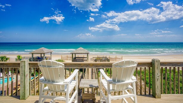 A wooden deck with white chairs overlooking a beach. - Oceanfront home with beach access, washer/dryer, central AC & golf nearby (North Topsail Beach)