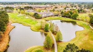 Un campo de golf con varios estanques y un club de campo.