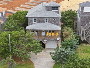 A two-story house with a covered porch, a garage, and a satellite dish.