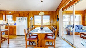 Ein Holzinterieur mit Esstisch, Stühlen und einem Kühlschrank.