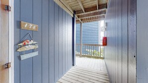 Un pontile di legno con ringhiera blu, un cartello di benvenuto e un cartello con un numero.