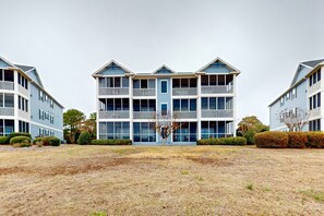 A multi-story building with balconies and a central entrance. - Mystic Marina A: Spacious condo with marina, pool access, streaming & AC (Southport)