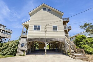 A two-story building with a covered entrance and a wooden deck. - Sandy Paws 394: Stunning Views, Pool Access, Pet-Friendly (Avon)