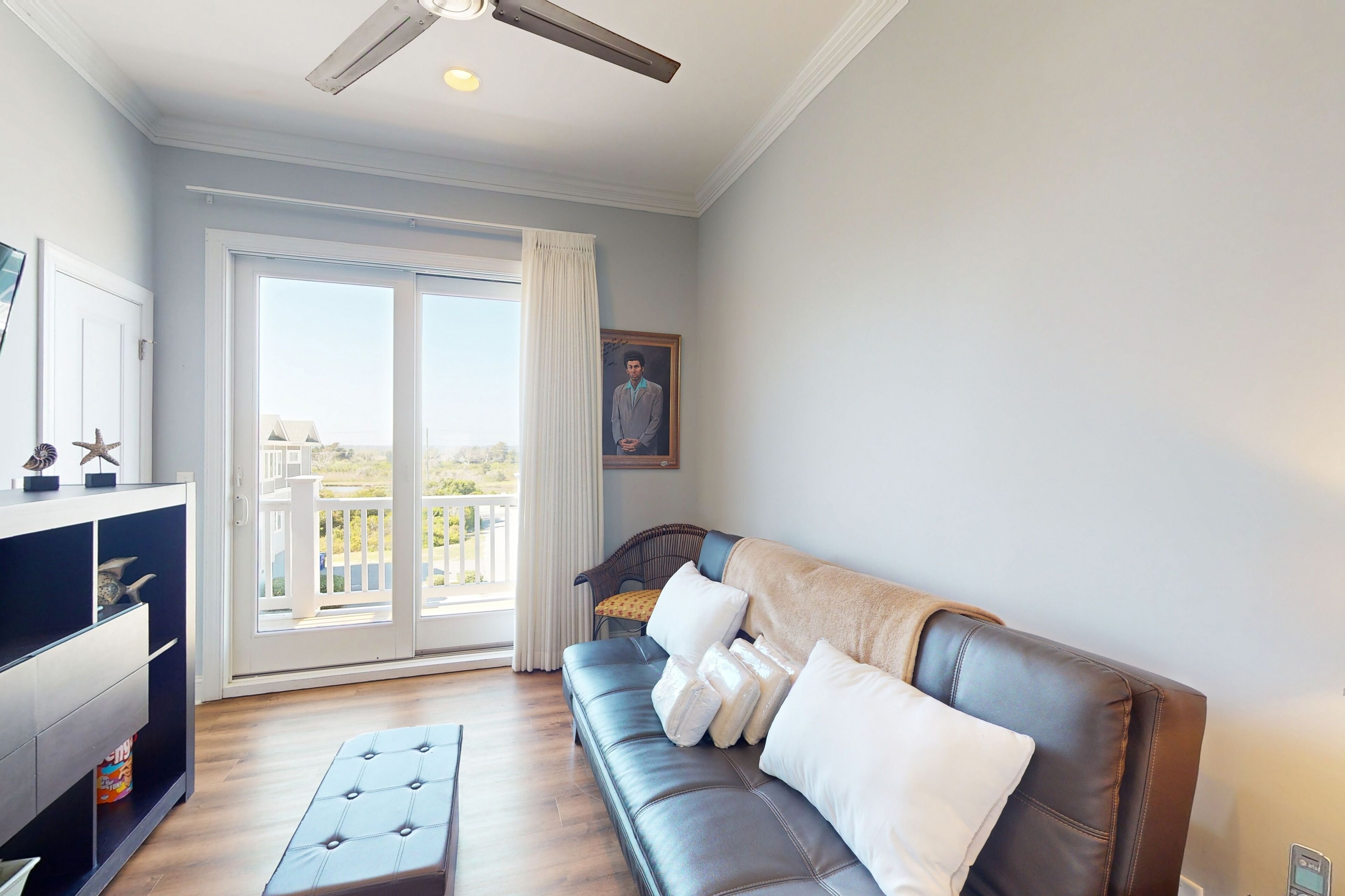 Een woonkamer met een leren bank, een glazen kast en een balkon met uitzicht.